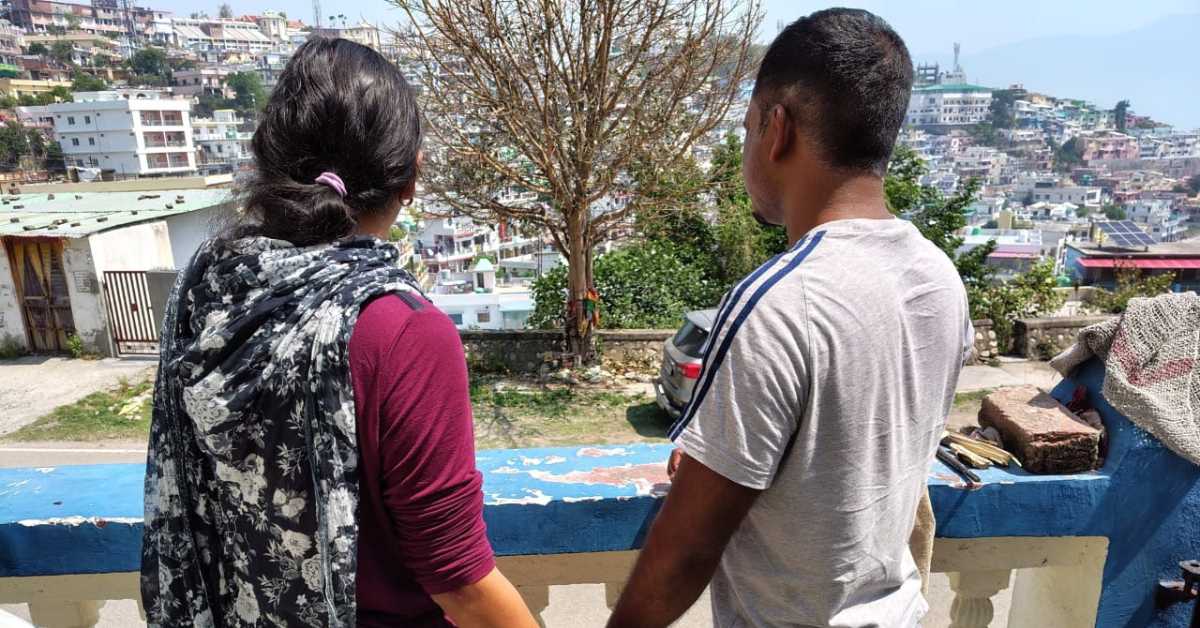 Priya and her husband stand together, persevering through trials and hardships